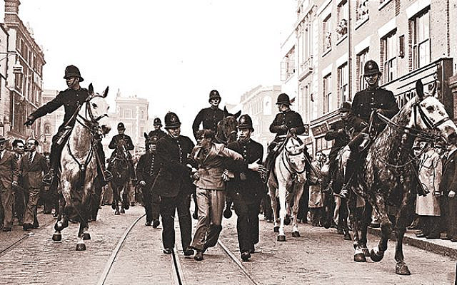 A demonstrator is taken away under arrest by police officers after a mounted baton charge, in East London, on Oct. 4, 1936, to stop fighting between anti-fascists and Sir Oswald Mosley's blackshirts. Via Jewish News