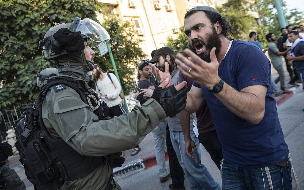 Israeli riot police face off with a Jewish man as clashes erupted between Arabs, police and Jews, in the mixed town of Lod, central Israel, Wednesday, May 12, 2021. (AP Photo/Heidi Levine) Israeli riot police face off with a Jewish man as clashes erupted between Arabs, police and Jews, in the mixed town of Lod, central Israel, Wednesday, May 12, 2021. (AP Photo/Heidi Levine)