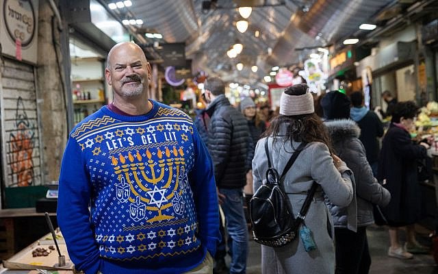 Illustrative: An American Jewish man wears a Hanukkah-themed sweater during Hanukkah at the Mahane Yehuda Market in Jerusalem, on December 25, 2019 (Hadas Parush/Flash90) Illustrative: An American Jewish man wears a Hanukkah-themed sweater during Hanukkah at the Mahane Yehuda Market in Jerusalem, on December 25, 2019 (Hadas Parush/Flash90)