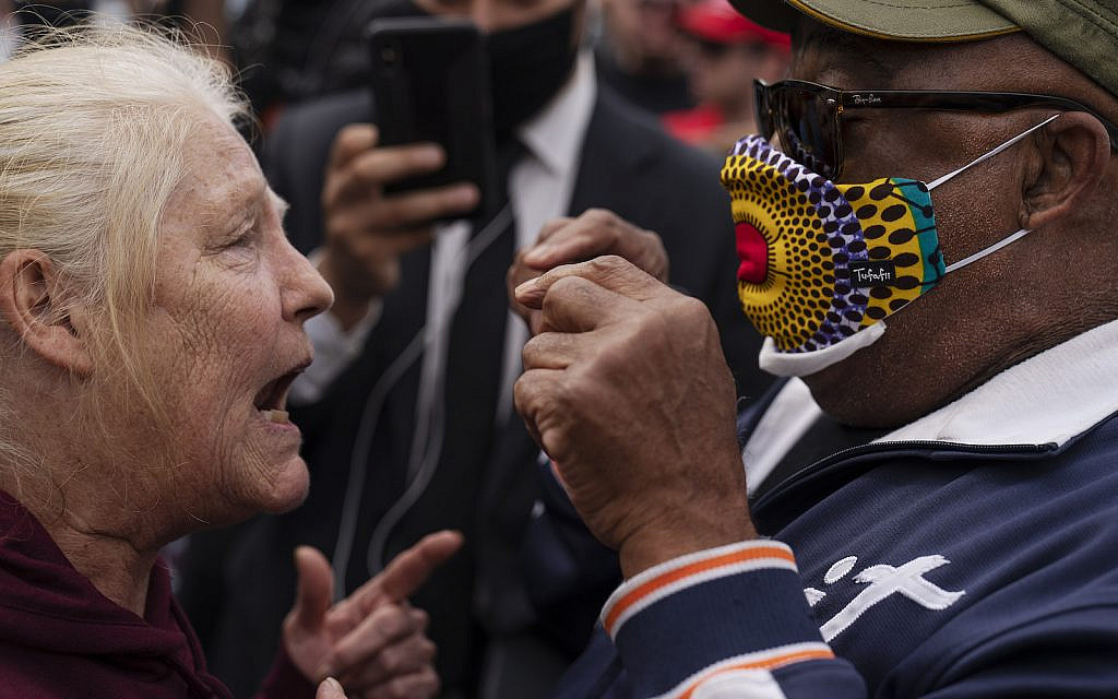 A Trump supporter at left argues with a counter protestor as Trump supporters demonstrate against the election results outside the central counting board at the TCF Center in Detroit, Mich., Nov. 5, 2020. (AP Photo/David Goldman)