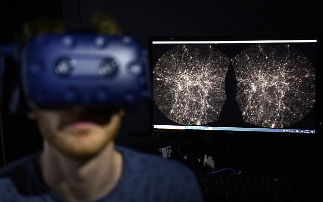 FILE - In this Oct. 12, 2021 file photo, Hadrien Gurnel, software engineer EPFL's Laboratory for Experimental Museology (eM+) explores with a virtual reality helmet the most detailed 3D map of the universe with the virtual reality software VIRUP, Virtual Reality Universe Project developed by Swiss Federal Institute of Technology, in St-Sulpice near Lausanne, Switzerland. The term metaverse seems to be everywhere. Facebook is hiring thousands of engineers in Europe to work on it, while video game companies are outlining their long-term visions for what some consider the next big thing on the internet. Essentially, it’s a world of endless, interconnected virtual communities where people can meet, work and play. You can go to a virtual concert, take a trip online and try on digital clothing. But tech companies still have to figure out how to connect their online platforms.(Laurent Gillieron/Keystone via AP)