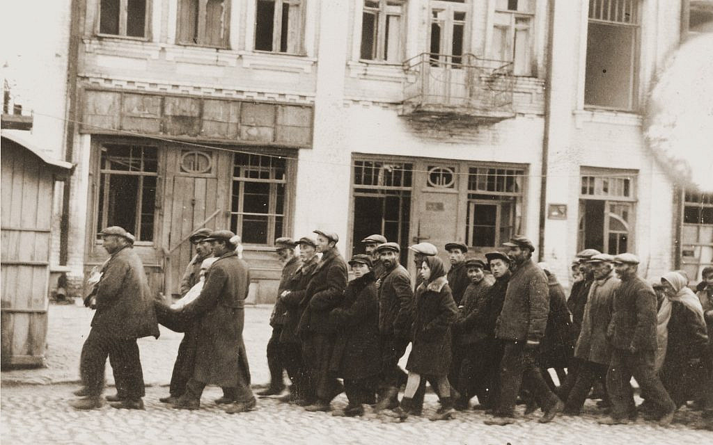 Jews are marched through the streets of Kamenets-Podolsk (Ukraine/USSR) to an execution site outside of the city, on August 27, 1941. (Gyula Spitz, Wikipedia)