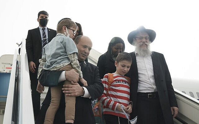Israeli Prime Minister Naftali Bennett welcomes a group of orphans from the Alumim orphanage in the Ukrainian city of Zhytomyr, on arrival to Israel at Ben Gurion Airport, Sunday, March 6, 2022.(AP Photo/Maya Alleruzzo, Pool)