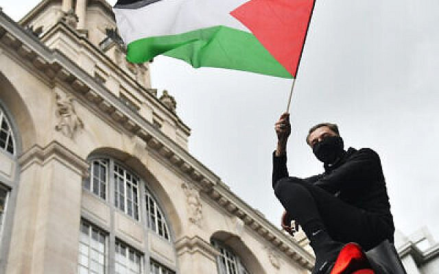 A demonstrator waves a Palestinian flag whilst sat atop a traffic light in London, during a march in solidarity with the people of Palestine amid the ongoing conflict with Israel. Picture date: Saturday May 15, 2021.