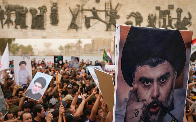 Followers of Shiite cleric Muqtada al-Sadr hold posters with his photo as they celebrate the passing of a law criminalizing the normalization of ties with Israel, in Tahrir Square, Baghdad, Iraq, Thursday, May 26, 2022. (AP Photo/Hadi Mizban)