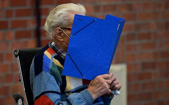Defendant Josef Schuetz hides his face behind a folder as he arrives for his trial in Brandenburg an der Havel, northeastern Germany, on October 7, 2021. (Tobias Schwarz/AFP)