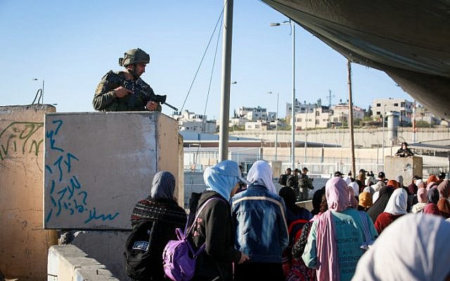 Muslim Palestinian women cross the Qalandiya checkpoint, outside of the West bank city of Ramallah, on April 15, 2022. (Flash90) Muslim Palestinian women cross the Qalandiya checkpoint, outside of the West bank city of Ramallah, on April 15, 2022. (Flash90)
