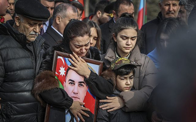 Relatives and friends mourn near the coffin with the body of Orkhan Rizvan Oglu Askarov, slain security chief of the Azerbaijan Embassy in Iran's capital during his farewell ceremony in Baku, Azerbaijan, Monday, Jan. 30, 2023. A gunman stormed the Azerbaijan Embassy in Iran's capital, killing its security chief and wounding two guards. (AP Photo/Aziz Karimov) Relatives and friends mourn near the coffin with the body of Orkhan Rizvan Oglu Askarov, slain security chief of the Azerbaijan Embassy in Iran's capital during his farewell ceremony in Baku, Azerbaijan, Monday, Jan. 30, 2023. A gunman stormed the Azerbaijan Embassy in Iran's capital, killing its security chief and wounding two guards. (AP Photo/Aziz Karimov)