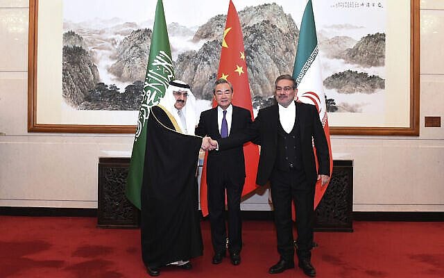 In this photo released by Xinhua News Agency, Ali Shamkhani, the secretary of Iran's Supreme National Security Council, at right, shakes hands with Saudi national security adviser Musaad bin Mohammed al-Aiban, at left, as Wang Yi, China's most senior diplomat, looks on, at center, for a photo during a closed meeting held in Beijing, Saturday, March 11, 2023. Iran and Saudi Arabia agreed Friday to reestablish diplomatic relations and reopen embassies after seven years of tensions. The major diplomatic breakthrough negotiated with China lowers the chance of armed conflict between the Mideast rivals, both directly and in proxy conflicts around the region. (Luo Xiaoguang/Xinhua via AP)