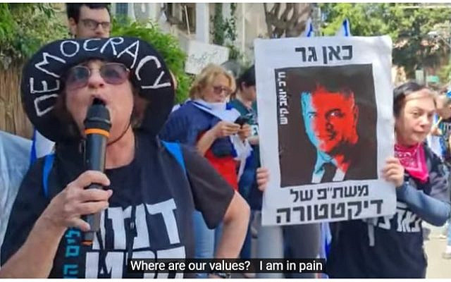 The author shouting at Minister Kisch. Sign says, "Here lives a collaborator with dictatorship."     photo credit: Nili Bresler
