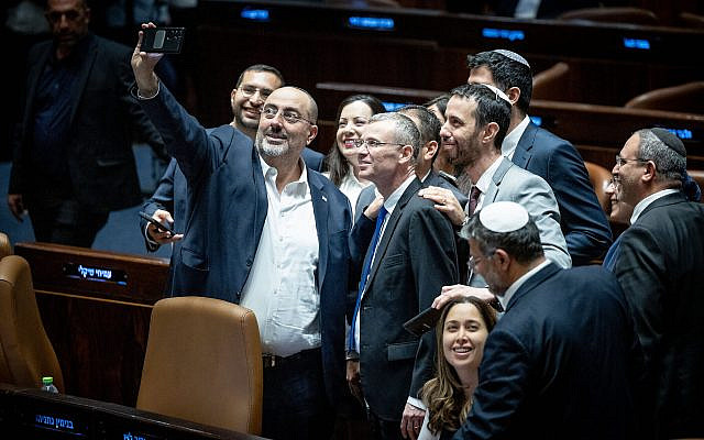 Coalition lawmakers take a celebratory selfie in the Knesset plenum, as they pass the first of the judicial overhaul laws, July 24, 2023. (Yonatan Sindel/Flash90)