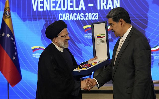 Iranian President Ebrahim Raisi shakes hands with Venezuelan President Nicolas Maduro, as he receives the Order of Libertador y Libertadora de Primera Clase, at Miraflores presidential palace in Caracas, Venezuela, June 12, 2023. (AP Photo/Ariana Cubillos)