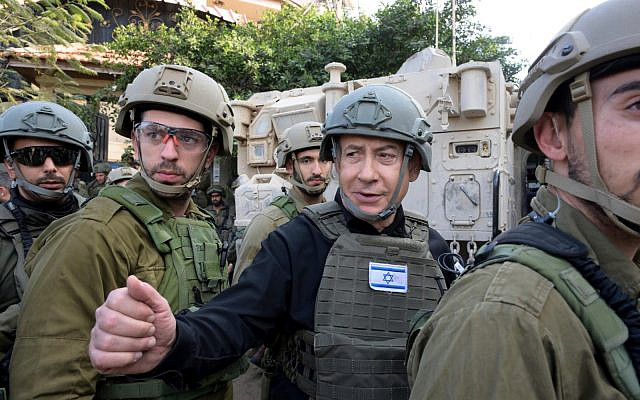 Israeli Prime Minister Benjamin Netanyahu, center, wears a protective vest and helmet as he receives a security briefing with commanders and soldiers in the northern Gaza Strip, on Monday, Dec. 25, 2023. (Avi Ohayon/GPO/Handout via AP)