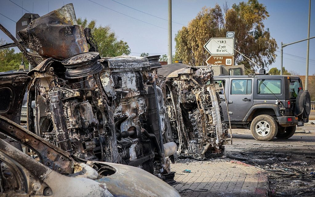 Israeli security seen next to burnt cars at the entrance to the Gaza border community of Kibbutz Be'eri, October 9, 2023. (Yossi Zamir/Flash90)