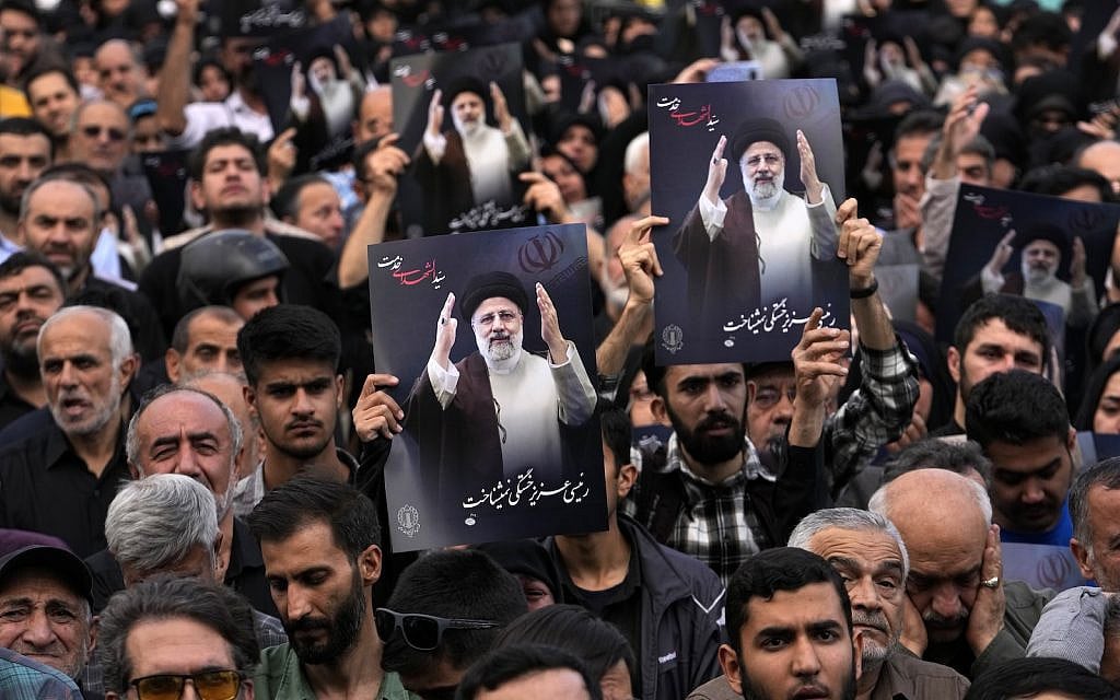 People hold up posters of President Ebrahim Raisi during a mourning ceremony for him at Vali-e-Asr square in downtown Tehran, Iran, Monday, May 20, 2024. (AP/Vahid Salemi)