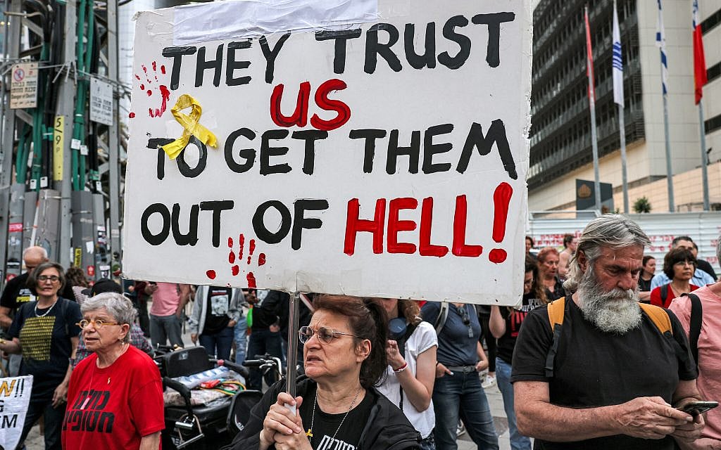 Protesters hold signs calling for the release of hostages held by terror groups in Gaza since October 7, outside the Kirya military base, Tel Aviv, April 18, 2024. (Ahmad Gharbli/AFP)