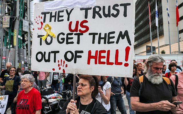 Protesters hold signs calling for the release of hostages held by terror groups in Gaza since October 7, outside the Kirya military base, Tel Aviv, April 18, 2024. (Ahmad Gharbli/AFP)