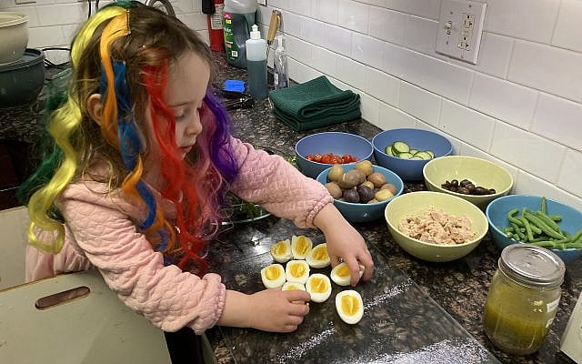 Our toddler practicing for Purim while exploring a (new to her) ingredient—soft boiled eggs!