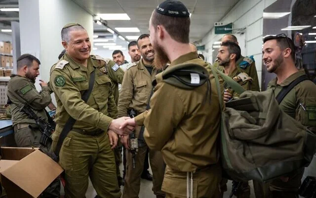 Maj. Gen. David Zini, the head of the IDF’s Training Command (left), greets an ultra-Orthodox soldier drafting to the IDF’s new Haredi brigade, known as the Hasmonean Brigade, January 5, 2025. (Israel Defense Forces) Maj. Gen. David Zini, the head of the IDF’s Training Command (left), greets an ultra-Orthodox soldier drafting to the IDF’s new Haredi brigade, known as the Hasmonean Brigade, January 5, 2025. (Israel Defense Forces)