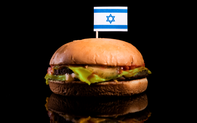Istock Israeli flag on top of sandwich with meat on black background.