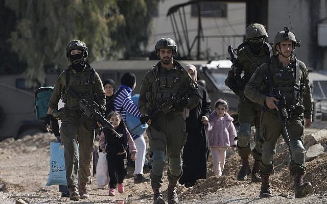 Israeli soldiers walk ahead of Palestinians who carry their belongings and were displaced by an Israeli military operation that evacuated the Jenin refugee camp in the West Bank on Jan. 23, 2025. (AP Photo/Majdi Mohammed) Israeli soldiers walk ahead of Palestinians who carry their belongings and were displaced by an Israeli military operation that evacuated the Jenin refugee camp in the West Bank on Jan. 23, 2025. (AP Photo/Majdi Mohammed)