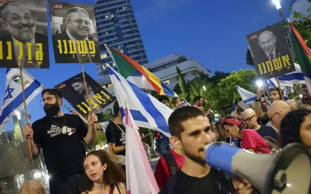 Demonstrators chant slogans and gather with pictures showing cabinet members in the current Israeli government during a rally against the government's judicial overhaul plan in Tel Aviv on September 23, 2023. (The Jewish Chronicle/Jack Guez/AFP)