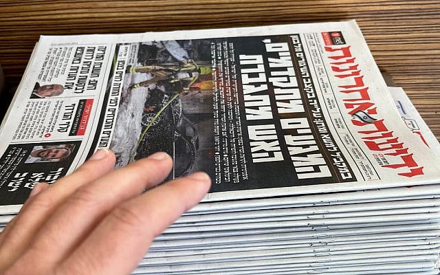 A pile of free newspapers in my local coffee shop - the reaching guilty hand is mine. Photo credit: Zev Farber's iphone13.