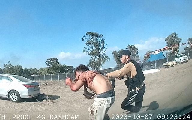 Militant abducting a man during the Re'im music festival massacre