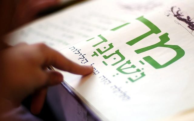 JERUSALEM - APRIL 02 2007:Jewish person reads the Haggadah. The Haggadah is a Jewish text that sets forth the order of the Passover Seder on Passover Jewish Holiday.