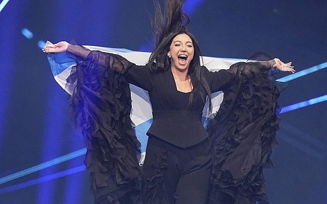Yuval Raphael from Israel holds her countries flag onstage during the Grand Final of the 69th Eurovision Song Contest, in Basel, Switzerland, Saturday, May 17, 2025. (AP/Martin Meissner)