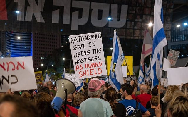 A protester in Tel Aviv holds a sign accusing Netanyahu's government of using the hostages as "human shields" to protect themselves. Credit Lindsey Levy