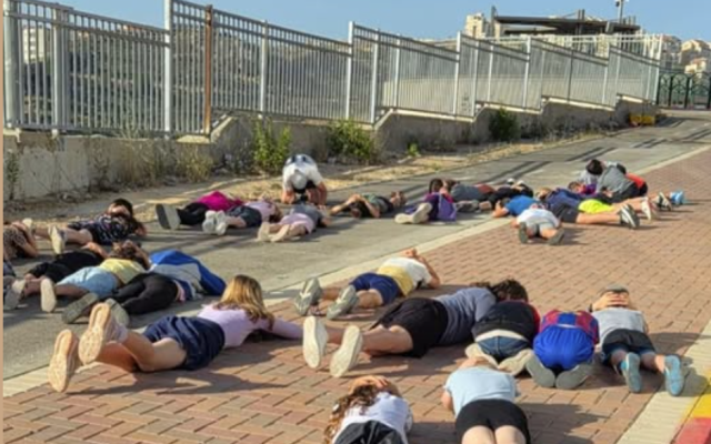 Kids lying down on the ground because of a siren that went off just as everyone was heading to school. (Sar-El Ben Tzvi)