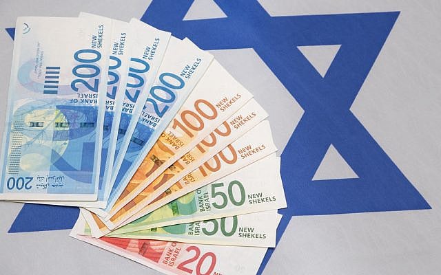 Israeli currency against the backdrop of an Israeli flag. (iStock)