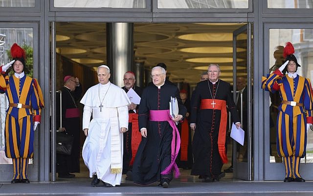 Pope Leo XIV, left, is flanked by Monsignor Leonardo Sapienza, second from left, after his meeting with the College of Cardinals in the New Synod Hall at the Vatican, May 10, 2025. (Vatican Media via AP)