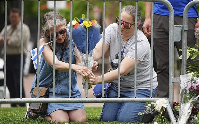 From left, Lisa Turnquist and Carrie Spyva-McIlvaine place a bouquet of flowers at a growing memorial outside of the Boulder County, Colo., courthouse Monday, June 2, 2025 after an attack on a group holding a march for the release of Israeli hostages in Gaza (AP Photo/David Zalubowski)