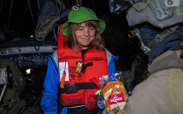 An Israeli soldier offers activist Greta Thunberg water and a pastrami sandwich after the military intecepted and boarded the boat on which she and other activists were seeking to break Israel's blockade on Gaza, early on June 9, 2025. (Foreign Ministry)