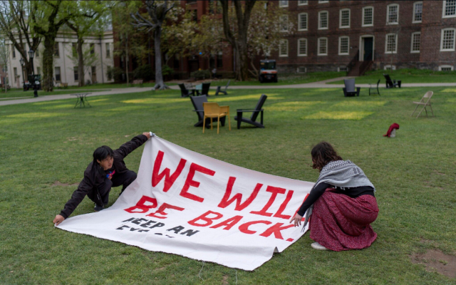 Pro-Palestinian demonstrators unfurl a banner on a lawn after an encampment protesting Israel over the Gaza war with Hamas was taken down at Brown University, April 30, 2024, in Providence, Rhode Island. (AP Photo/David Goldman)