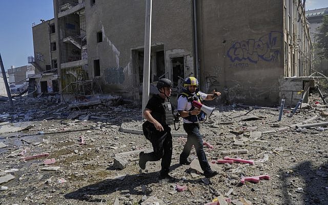 Israeli security forces and emergency teams work next to an unpopulated building after it was hit by a missile fired from Iran, in Haifa, June 20, 2025. (AP Photo/Baz Ratner)