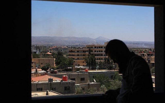 A man stands at a window as smoke billows during Israeli strikes in the vicinity of Syria's southern city of Sweida on July 16, 2025. (Bakr ALKASEM / AFP) A man stands at a window as smoke billows during Israeli strikes in the vicinity of Syria's southern city of Sweida on July 16, 2025. (Bakr ALKASEM / AFP)