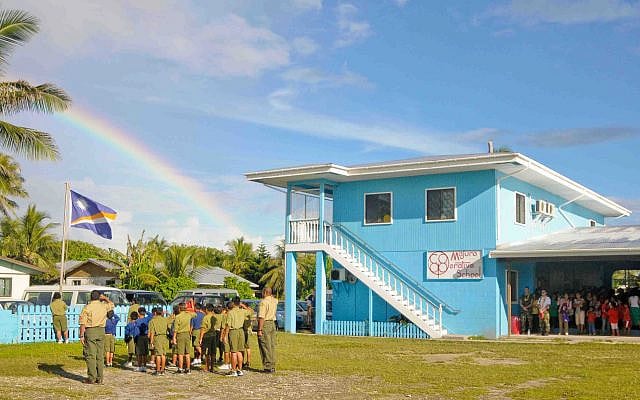 Students at the Majuro Cooperative School raise the Marshall Islands flag (Photo by Joshua Valcarcel, public domain)