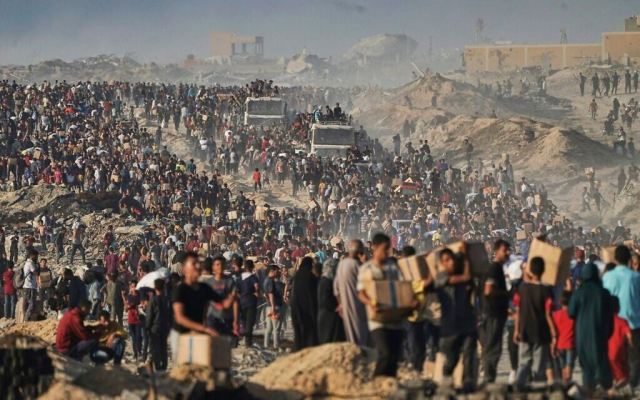 Palestinians get food and humanitarian aid, unloaded from a World Food Program in Gaza, June 16, 2025. (AP Photo/Jehad Alshrafi)