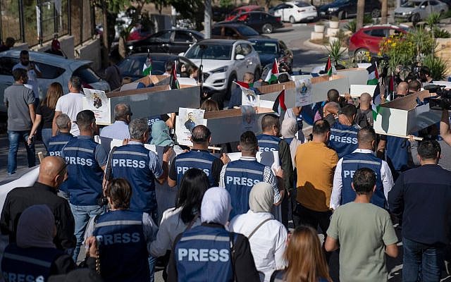 Palestinian journalists carry mock coffins of Palestinian journalists who were killed during the current war in Gaza during a symbolic funeral toward a United Nations office, in the West Bank city of Ramallah, November 7, 2023. (AP Photo/Nasser Nasser)