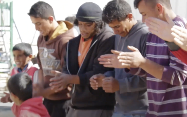 Awdah Hathaleen (wearing hat) dances with his neighbors, ca. 2017 (screenshot from "Territory Stories")