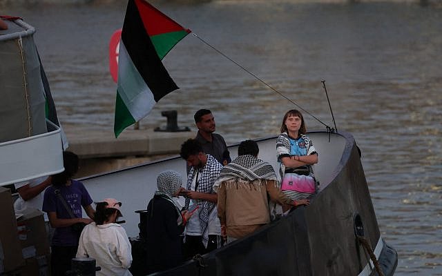Swedish climate activist Greta Thunberg (R) is seen on board of a vessel of a civilian flotilla, carrying pro-Palestinian and anti-Israel activists, and humanitarian aid and aiming to break the blockade of the Gaza Strip, moored at Barcelona port on September 1, 2025 (Lluis GENE / AFP)