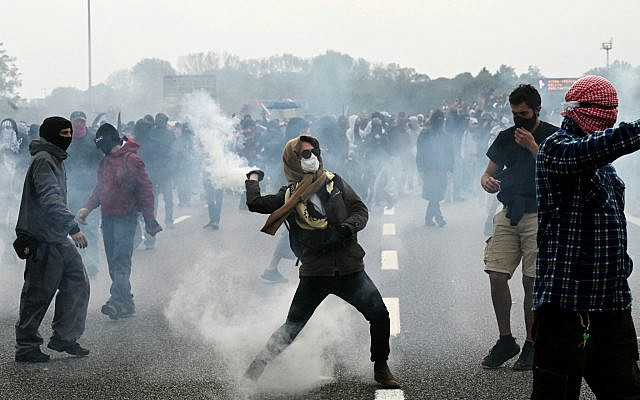 Pro-Palestinian, anti-Israel demonstrators clash with police during the protest on the Milan's highway against the interception of the Global Sumud Flotilla, on October 3, 2025. (Stefano RELLANDINI / AFP)