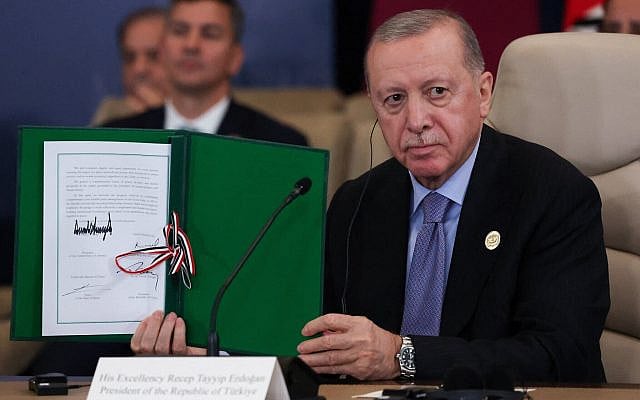 Turkish President Recep Tayyip Erdogan holds a signed document during a summit to support ending the two-year Israel-Hamas war in Gaza after a ceasefire deal, October 13, 2025, in Sharm El Sheikh, Egypt. (Suzanne Plunkett/Pool via AP)