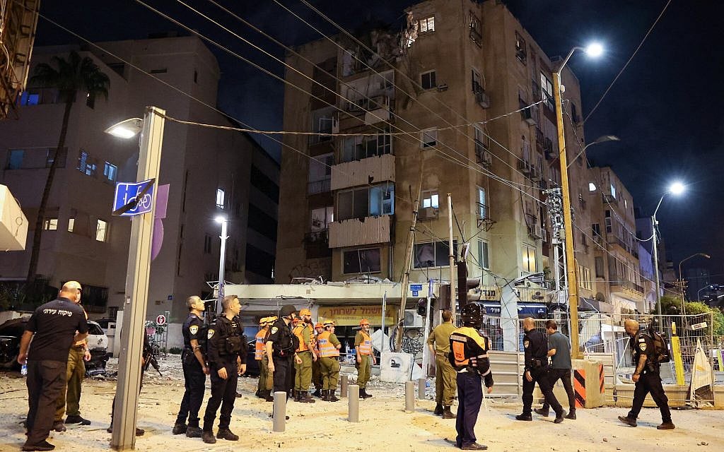 Israeli security forces and rescuers gather in front of a building in Tel Aviv that was hit by a rocket fired from the Gaza Strip on October 7, 2023. (JACK GUEZ / AFP)