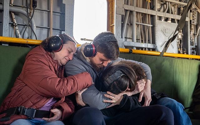 Freed hostage Sasha Troufanov, center, embraces his mother Yelena, left, and his girlfriend Sapir Cohen in an Israeli Air Force helicopter on the way from the Gaza border area to Sheba-Tel Hashomer Medical Center near Tel Aviv, February 15, 2025. (IDF)