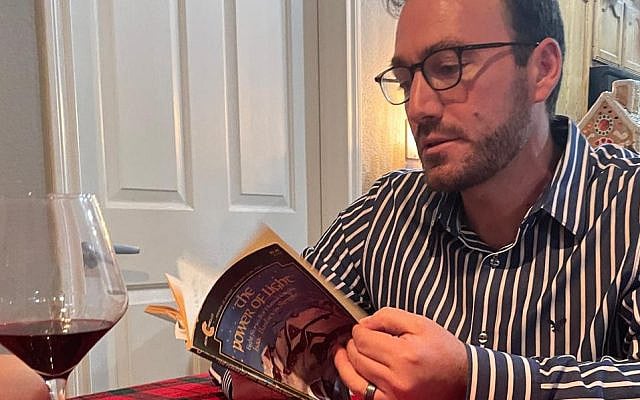 The author reading to his family during Hanukkah, 2023.