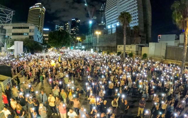Crowds near Hostages Square in Tel Aviv light up their phones during the singing of Hatikva, Israel's national anthem, at the end of a rally urging the return of the bodies of slain hostages held in Gaza, October 18, 2025. (Gilad Furst / Pro-Democracy Protest Movement)